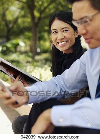 A businesswoman and businessman enjoying a break outdoors View Large Photo Image Stock Photo - A businesswoman and businessman enjoying a break outdoors. Fotosearch