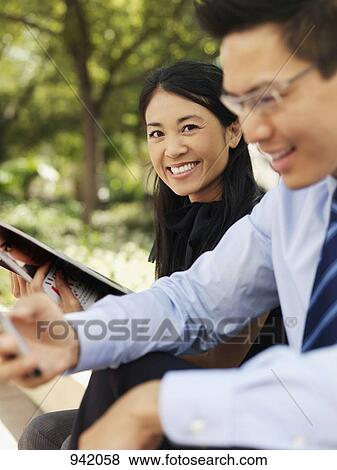 Stock Photo - A businesswoman and businessman enjoying a break outdoors. Fotosearch
