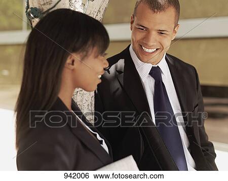 A businesswoman and businessman talking outside View Large Photo Image Stock Photograph - A businesswoman and businessman talking outside. Fotosearch