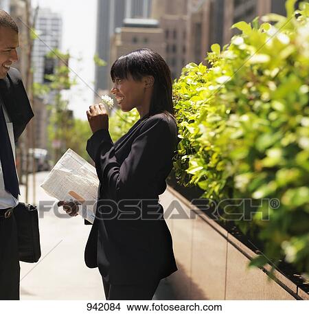 A businesswoman receiving a sprig of flowers from a businessman View Large Photo Image Picture - A businesswoman receiving a sprig of flowers from a businessman. Fotosearch
