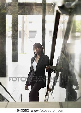 A businesswoman standing on a staircase View Large Photo Image Stock Image - A businesswoman standing on a staircase. Fotosearch