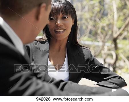 A businesswoman talking with a businessman, outdoors View Large Photo Image Stock Photograph - A businesswoman talking with a businessman, outdoors. Fotosearch