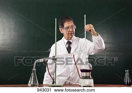 A chemistry teacher conducting an experiment in a classroom View Large Photo Image Stock Image - A chemistry teacher conducting an experiment in a classroom. Fotosearch