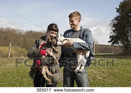 A couple holding kid goats View Large Photo Image Stock Photo - A couple holding kid goats. Fotosearch