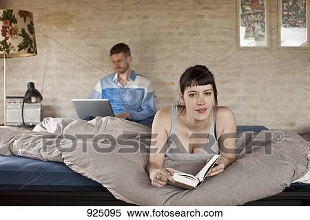 A couple relaxing in their bedroom View Large Photo Image Stock Photography - A couple relaxing in their bedroom. Fotosearch