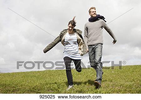 A couple running down a hill while holding hands View Large Photo Image Stock Photography - A couple running down a hill while holding hands. Fotosearch