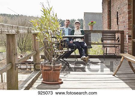 A couple sitting on a balcony View Large Photo Image Stock Image - A couple sitting on a balcony. Fotosearch
