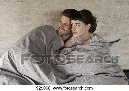 A couple snuggling in bed View Large Photo Image Stock Photo - A couple snuggling in bed. Fotosearch
