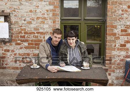 A couple with a map having lattes at an outdoor cafe View Large Photo Image Stock Photography - A couple with a map having lattes at an outdoor cafe. Fotosearch