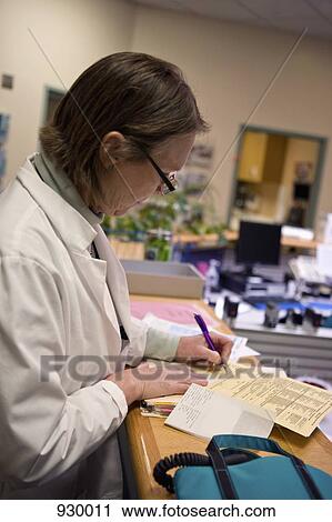 A doctor making notes on a medical chart View Large Photo Image Stock Image - A doctor making notes on a medical chart. Fotosearch
