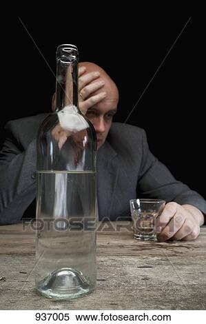 A drunk and depressed businessman holding a glass of vodka View Large Photo Image Stock Photography - A drunk and depressed businessman holding a glass of vodka. Fotosearch