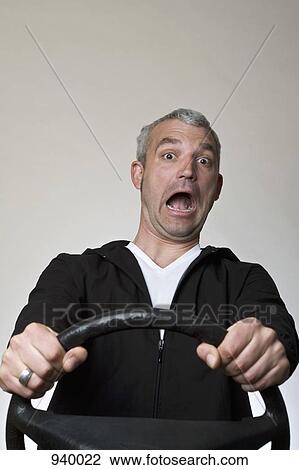 A frightened man behind a car steering wheel View Large Photo Image Stock Image - A frightened man behind a car steering wheel. Fotosearch