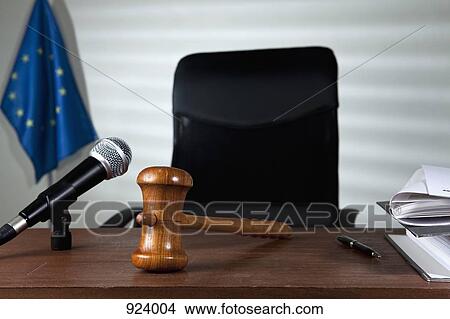Picture - A gavel on a judge's desk in an empty courtroom. Fotosearch