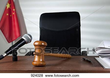 Stock Photo - A gavel on a judge's desk in an empty courtroom. Fotosearch