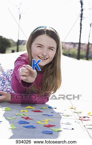 Stock Photograph - A girl holding a felt letter K. Fotosearch
