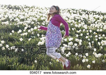 A girl jumping in a field of flowers View Large Photo Image Stock Photo - A girl jumping in a field of flowers. Fotosearch