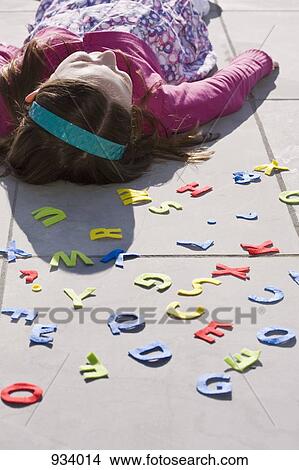 A girl lying down behind felt alphabet letters View Large Photo Image Picture - A girl lying down behind felt alphabet letters. Fotosearch
