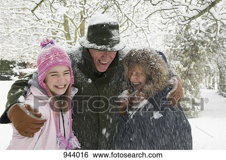 Stock Photograph - A girl with her grandparents in the snow. Fotosearch