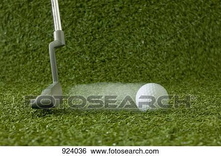 Stock Photograph - A golfer putting, detail of ball and putter head. Fotosearch