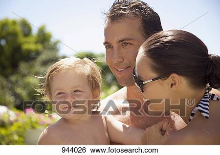 Stock Photograph - A man and a woman outdoors with a baby boy. Fotosearch