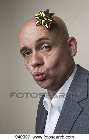 A man puckering his lips and wearing a gift bow on his head View Large Photo Image Stock Photo - A man puckering his lips and wearing a gift bow on his head. Fotosearch