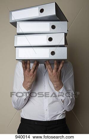 A man standing behind a stack folders View Large Photo Image Picture - A man standing behind a stack folders. Fotosearch
