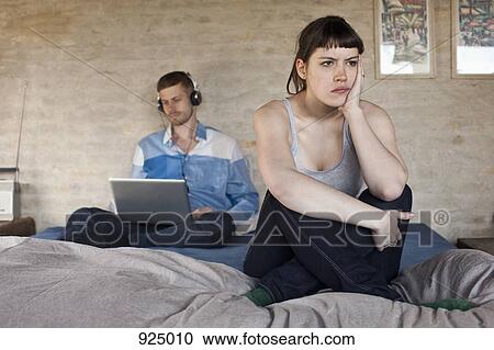 A man using a laptop and ignoring his frustrated girlfriend View Large Photo Image Stock Image - A man using a laptop and ignoring his frustrated girlfriend. Fotosearch