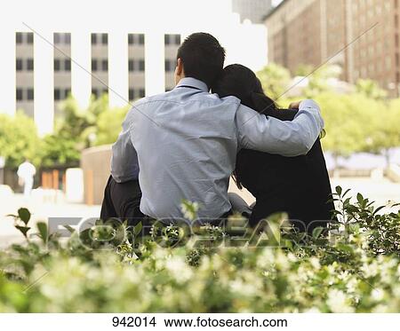 A man with his arm around his girlfriend View Large Photo Image Picture - A man with his arm around his girlfriend. Fotosearch