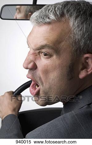 A man yelling over his shoulder whilst driving a car View Large Photo Image Stock Photography - A man yelling over his shoulder whilst driving a car. Fotosearch