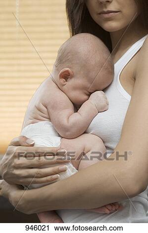 A mother holding her sleeping baby View Large Photo Image Stock Image - A mother holding her sleeping baby. Fotosearch