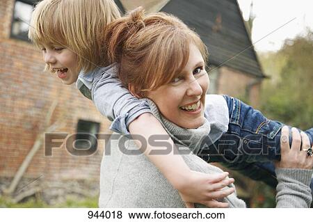 A mother holding her son over her shoulder View Large Photo Image Stock Photo - A mother holding her son over her shoulder. Fotosearch