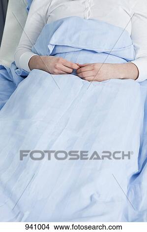 Picture - A patient lying in a hospital bed, directly above. Fotosearch