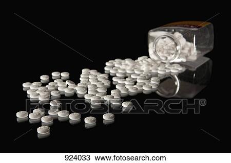 Stock Image - A pill bottle with scattered pills. Fotosearch