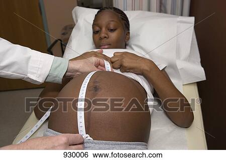 A pregnant woman getting her abdomen measured by a doctor View Large Photo Image Stock Photograph - A pregnant woman getting her abdomen measured by a doctor. Fotosearch