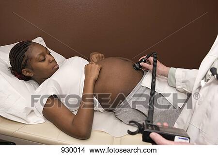 A pregnant woman receiving an ultrasound View Large Photo Image Picture - A pregnant woman receiving an ultrasound. Fotosearch