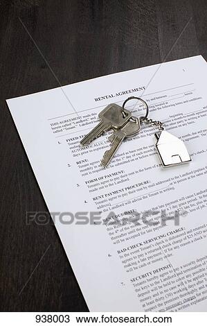 Stock Image - A rental agreement and two keys on a house shaped key ring. Fotosearch