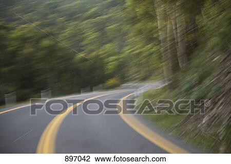 A road curving around a hillside, blurred motion View Large Photo Image Stock Image - A road curving around a hillside, blurred motion. Fotosearch