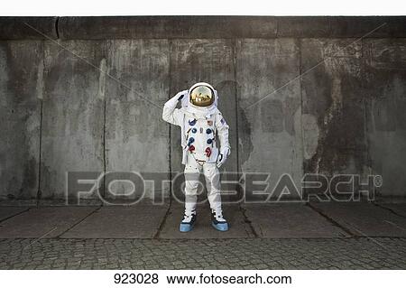 A saluting astronaut standing on a sidewalk in a city View Large Photo Image Stock Photo - A saluting astronaut standing on a sidewalk in a city. Fotosearch