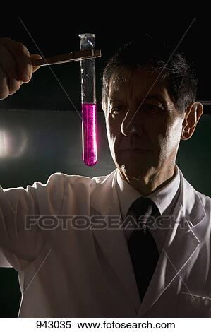 A scientist looking at a test tube of liquid View Large Photo Image Stock Photography - A scientist looking at a test tube of liquid. Fotosearch