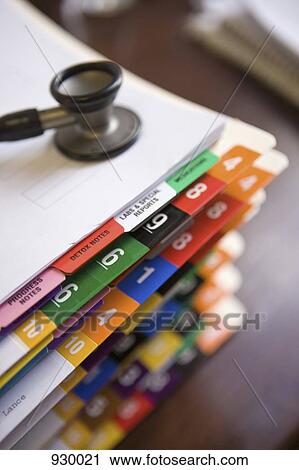 Stock Image - A stethoscope on top of a stack of patient files. Fotosearch