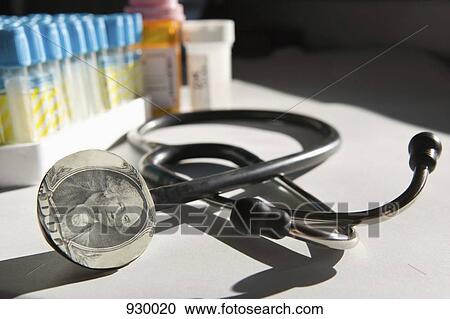 A stethoscope with a dollar bill on it and medicine in the background View Large Photo Image Stock Image - A stethoscope with a dollar bill on it and medicine in the background. Fotosearch