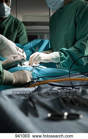 A surgery team operating on a patient in an operating room View Large Photo Image Stock Image - A surgery team operating on a patient in an operating room. Fotosearch