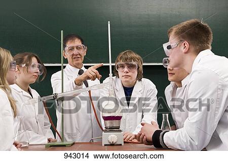 A teacher showing his students a chemistry experiment View Large Photo Image Picture - A teacher showing his students a chemistry experiment. Fotosearch