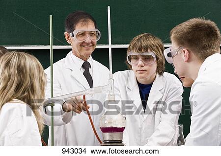 A teacher showing his students a chemistry experiment View Large Photo Image Picture - A teacher showing his students a chemistry experiment. Fotosearch