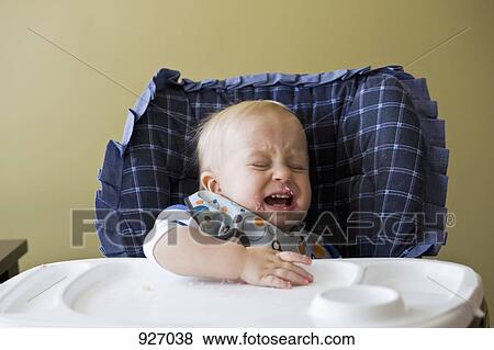 Stock Photo - A toddler crying in his high chair. Fotosearch