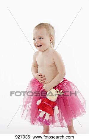 A toddler wearing a tutu and holding a stuffed toy, studio shot View Large Photo Image Stock Photograph - A toddler wearing a tutu and holding a stuffed toy, studio shot. Fotosearch