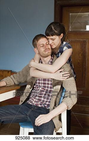 Stock Photo - A woman embracing her boyfriend. Fotosearch