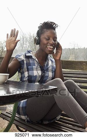 A woman listening to headphones, singing and dancing View Large Photo Image Stock Image - A woman listening to headphones, singing and dancing. Fotosearch