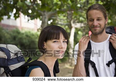 A woman looking irritated while her boyfriend smiles at her, focus on woman View Large Photo Image Picture - A woman looking irritated while her boyfriend smiles at her, focus on woman. Fotosearch