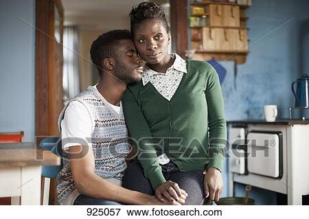 Stock Photo - A woman sitting on her boyfriend's lap. Fotosearch